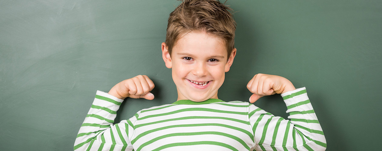 Kleines Kind freut sich an der Schultafel